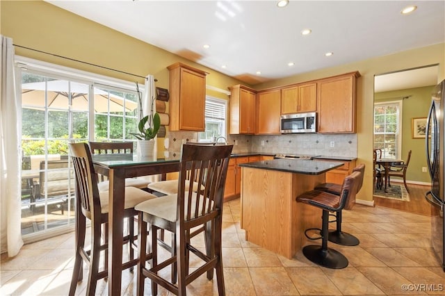 2024 Rose Family Dr, Midlothian, VA 23112 - kitchen with stainless steel microwave, backsplash, recessed lighting, a center island, and dark countertops