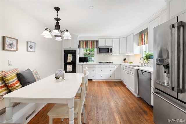 2740 Rettig Rd, Richmond, VA 23225 - kitchen featuring appliances with stainless steel finishes, white cabinets, a chandelier, light countertops, and hanging light fixtures