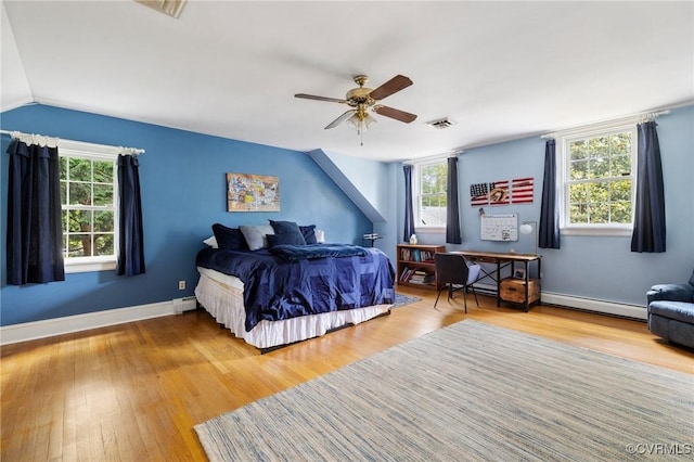 2740 Rettig Rd, Richmond, VA 23225 - bedroom featuring multiple windows, a baseboard radiator, wood finished floors, a ceiling fan, and lofted ceiling