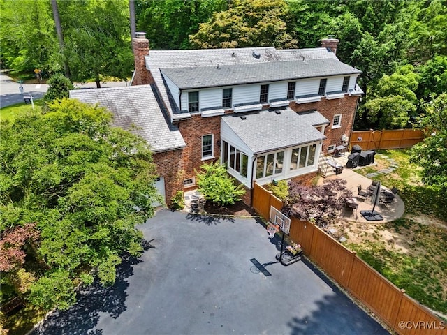 2740 Rettig Rd, Richmond, VA 23225 - back of property featuring a chimney, a sunroom, brick siding, a forest view, and driveway