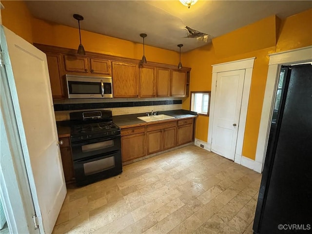 1527 National St, Richmond, VA 23231 - kitchen with double oven range, stainless steel microwave, dark countertops, brown cabinetry, and hanging light fixtures