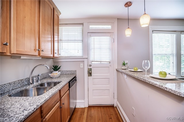 1112 Roseneath Rd Unit U1, Richmond, VA 23230 - kitchen with light wood-style floors, pendant lighting, stainless steel dishwasher, light stone counters, and brown cabinetry