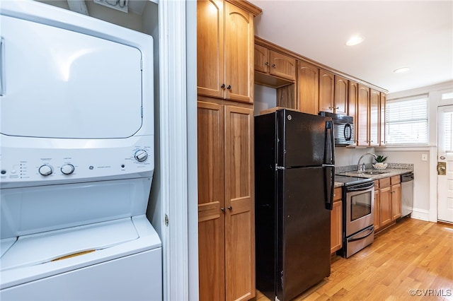 1112 Roseneath Rd Unit U1, Richmond, VA 23230 - kitchen featuring black appliances, estacked washer and dryer, light wood-type flooring, recessed lighting, and brown cabinets