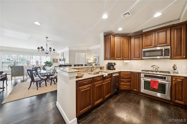 1231 Byrd Ave Unit 2C, Henrico, VA 23226 - kitchen with appliances with stainless steel finishes, ornamental molding, a chandelier, light stone countertops, and dark wood finished floors