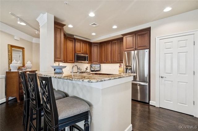 1231 Byrd Ave Unit 2C, Henrico, VA 23226 - kitchen with appliances with stainless steel finishes, dark wood finished floors, light stone countertops, a peninsula, and a kitchen breakfast bar