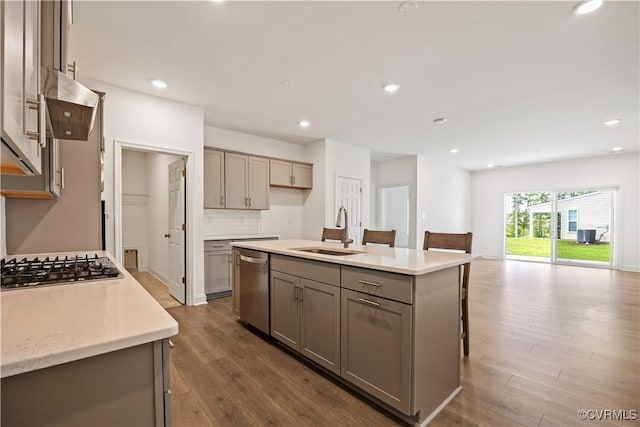 7204 Leire Ln, Moseley, VA 23832 - kitchen with gray cabinetry, stainless steel appliances, extractor fan, dark wood-style flooring, and light countertops