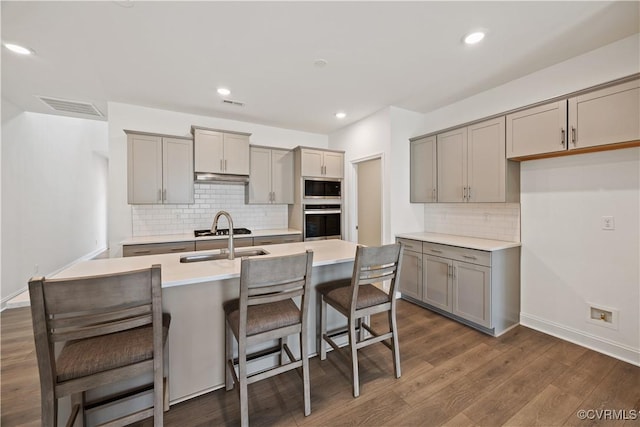7204 Leire Ln, Moseley, VA 23832 - kitchen featuring gray cabinetry, stainless steel appliances, decorative backsplash, a kitchen breakfast bar, and recessed lighting