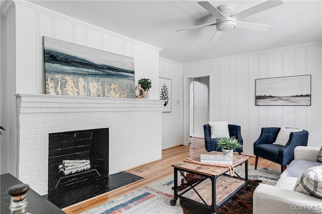 7654 Cherokee Rd, Richmond, VA 23225 - living room with light wood-style floors, ceiling fan, crown molding, and a brick fireplace