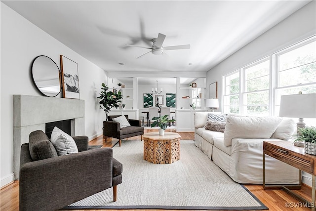 7654 Cherokee Rd, Richmond, VA 23225 - living area with a ceiling fan, light wood-type flooring, a fireplace, and a chandelier
