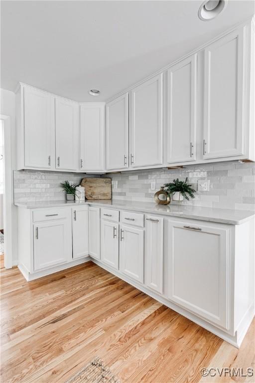 7654 Cherokee Rd, Richmond, VA 23225 - kitchen with light countertops, white cabinetry, decorative backsplash, and light wood-style floors