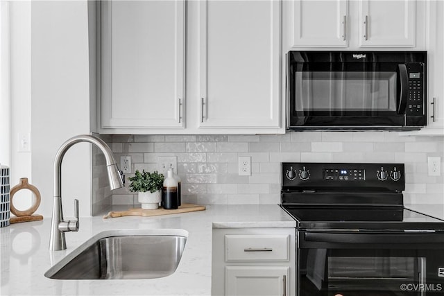 7654 Cherokee Rd, Richmond, VA 23225 - kitchen with black appliances, white cabinetry, tasteful backsplash, and light stone countertops