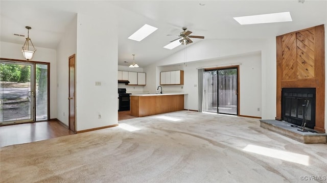 4804 Hackney Rd, Richmond, VA 23234 - unfurnished living room with a skylight, lofted ceiling, light colored carpet, ceiling fan, and a large fireplace