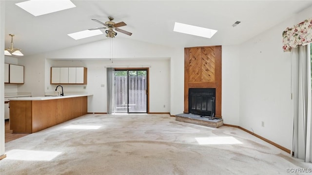 4804 Hackney Rd, Richmond, VA 23234 - unfurnished living room featuring a skylight, vaulted ceiling, a fireplace, and light carpet
