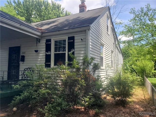 1507 Carter St, Richmond, VA 23220 - view of home's exterior featuring a chimney and roof with shingles