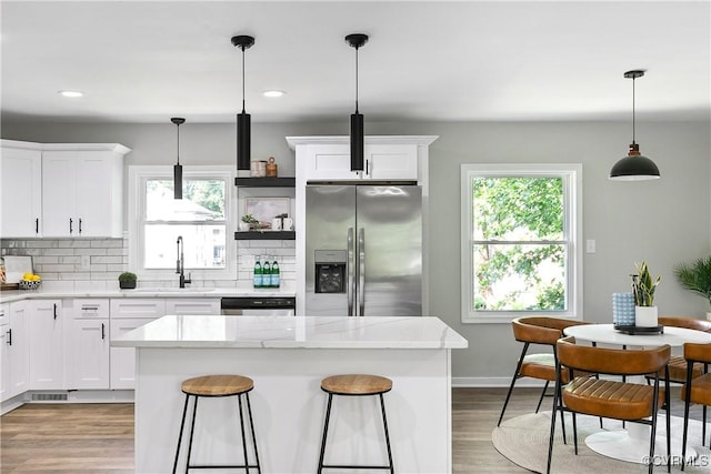 2914 Griffin Ave, Richmond, VA 23222 - kitchen with stainless steel fridge with ice dispenser, wood finished floors, dishwashing machine, tasteful backsplash, and white cabinets