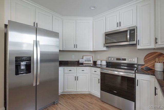 4806 Cutshaw Ave, Richmond, VA 23230 - kitchen featuring appliances with stainless steel finishes, white cabinetry, light wood-style floors, and dark stone counters