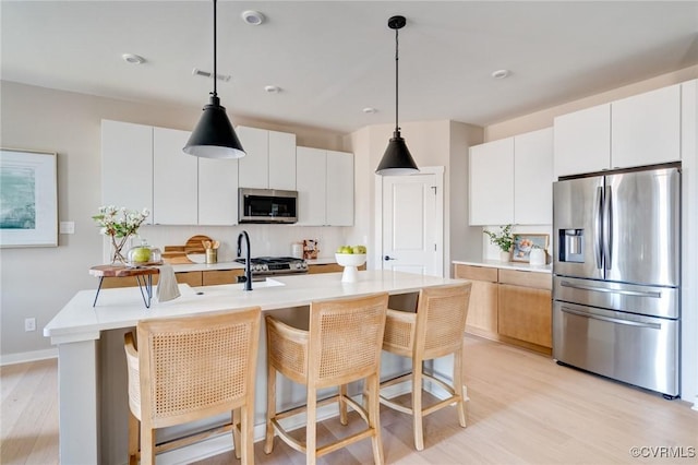 15730 Canoe Pointe Loop, Moseley, VA 23120 - kitchen featuring stainless steel appliances, light countertops, light wood-type flooring, and decorative light fixtures