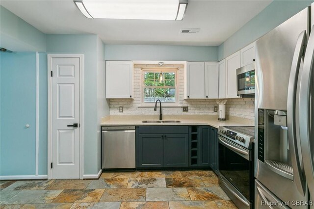 5 Hadley Pl, Newport News, VA 23608 - kitchen with stainless steel appliances, decorative backsplash, white cabinets, and light countertops