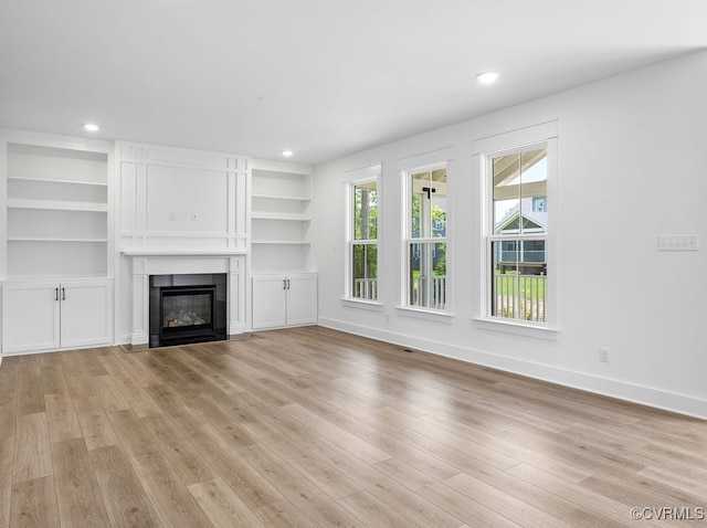 13513 Pinstone Ct, Midlothian, VA 23112 - unfurnished living room with light wood-style flooring, a fireplace with flush hearth, recessed lighting, and built in shelves