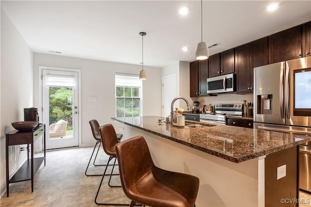 1931 Kennington Park Rd, King William, VA 23009 - kitchen with appliances with stainless steel finishes, a center island with sink, a kitchen breakfast bar, dark brown cabinets, and recessed lighting