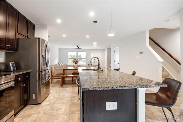 1931 Kennington Park Rd, King William, VA 23009 - kitchen featuring a breakfast bar, dark brown cabinetry, a kitchen island with sink, ceiling fan, and open floor plan