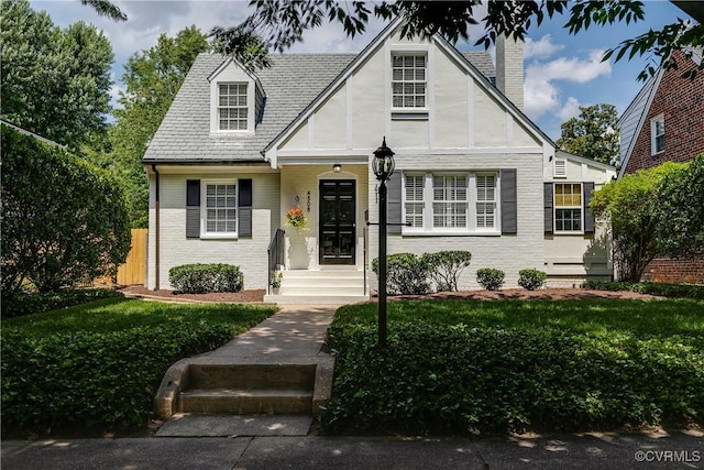 4508 Augusta Ave, Richmond, VA 23230 - tudor home featuring brick siding, a chimney, and a front yard