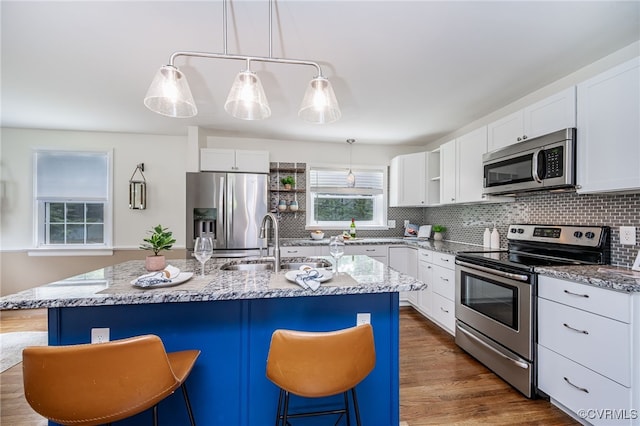 8411 Freestone Ave, Henrico, VA 23229 - kitchen featuring appliances with stainless steel finishes, light stone countertops, decorative backsplash, and a kitchen bar
