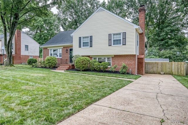 8411 Freestone Ave, Henrico, VA 23229 - split level home featuring brick siding, a chimney, and driveway