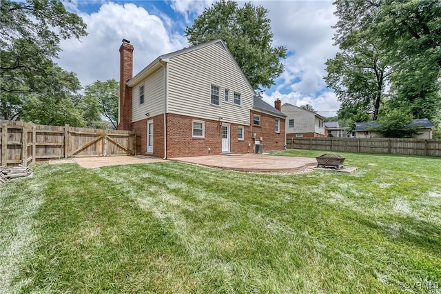 8411 Freestone Ave, Henrico, VA 23229 - back of property with a chimney, a fire pit, a patio, a fenced backyard, and brick siding