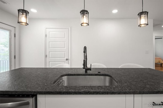 1508 N 29th St, Richmond, VA 23223 - kitchen featuring stainless steel dishwasher, dark stone countertops, white cabinets, and recessed lighting