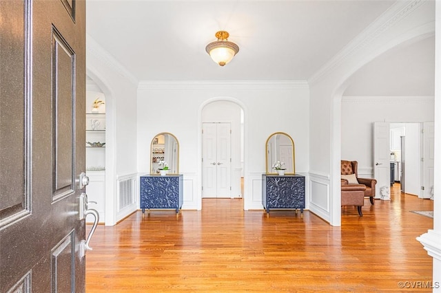 12829 Huntmaster Ln, Henrico, VA 23233 - entryway with arched walkways, light wood-style floors, ornamental molding, wainscoting, and a decorative wall