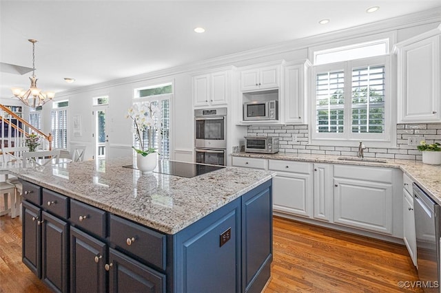 12829 Huntmaster Ln, Henrico, VA 23233 - kitchen with stainless steel appliances, white cabinetry, a chandelier, crown molding, and a center island