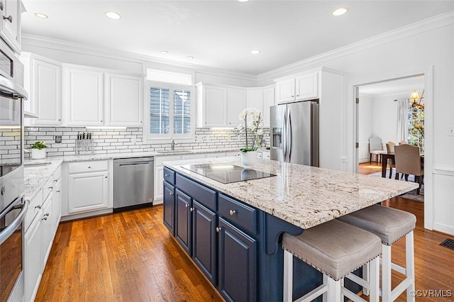 12829 Huntmaster Ln, Henrico, VA 23233 - kitchen featuring appliances with stainless steel finishes, blue cabinetry, white cabinets, a breakfast bar area, and wood finished floors