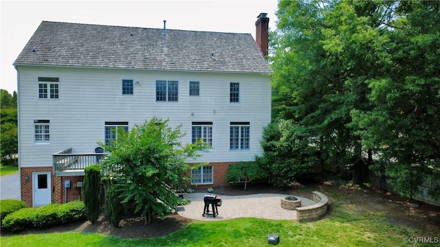 12829 Huntmaster Ln, Henrico, VA 23233 - back of house featuring a fire pit, a chimney, a patio area, brick siding, and a yard