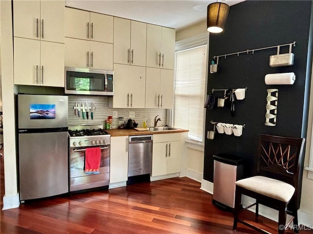2227 Park Ave, Richmond, VA 23220 - kitchen featuring appliances with stainless steel finishes, dark wood-style flooring, backsplash, and hanging light fixtures