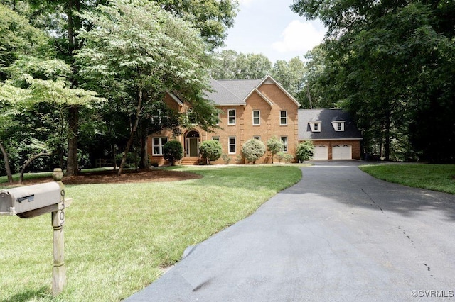 9307 Oak Trl, Ashland, VA 23005 - colonial-style house featuring driveway, a front yard, and brick siding
