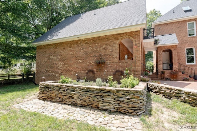9307 Oak Trl, Ashland, VA 23005 - view of property exterior with a shingled roof, brick siding, and a balcony