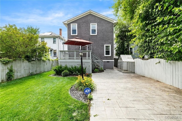 2805 Griffin Ave, Richmond, VA 23222 - back of house with a fenced backyard, a deck, an outdoor structure, a patio area, and stucco siding