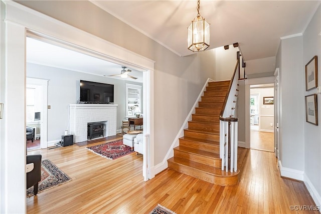 5013 Caledonia Rd, Richmond, VA 23225 - stairway with wood finished floors, a fireplace, crown molding, and a chandelier