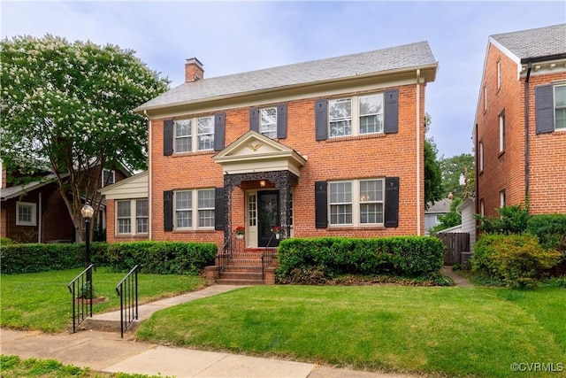 5013 Caledonia Rd, Richmond, VA 23225 - view of front of house with brick siding, a chimney, and a front yard