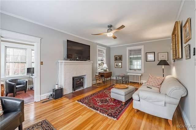 5013 Caledonia Rd, Richmond, VA 23225 - living room featuring radiator, wood finished floors, a ceiling fan, crown molding, and built in shelves