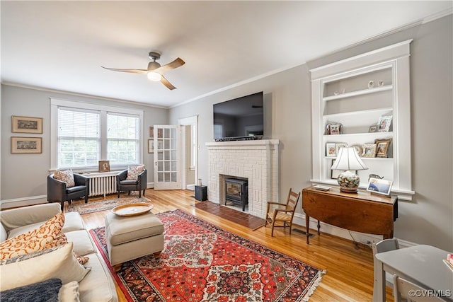 5013 Caledonia Rd, Richmond, VA 23225 - living room featuring a ceiling fan, wood finished floors, ornamental molding, and a brick fireplace