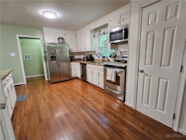 7106 Full Rack Dr, Midlothian, VA 23112 - kitchen with appliances with stainless steel finishes, wood finished floors, and white cabinetry