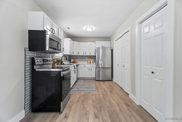 5908 Meadwood Cir, Chesterfield, VA 23234 - kitchen with appliances with stainless steel finishes, light wood-type flooring, white cabinetry, decorative backsplash, and light countertops