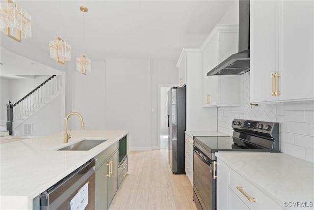 2013 N Ave, Richmond, VA 23222 - kitchen with stainless steel appliances, wall chimney exhaust hood, light wood-type flooring, decorative backsplash, and white cabinets