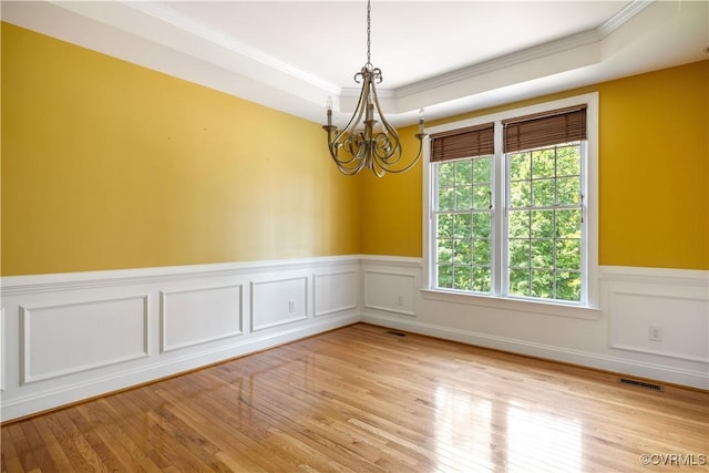 706 Colony Oak Ln, Midlothian, VA 23114 - spare room with a chandelier, a tray ceiling, ornamental molding, wainscoting, and light wood-style flooring