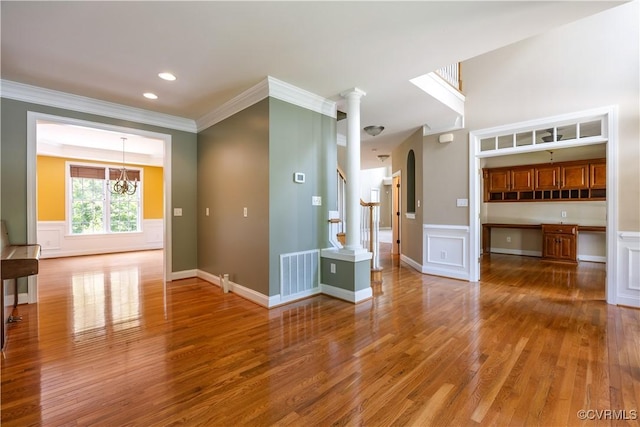 706 Colony Oak Ln, Midlothian, VA 23114 - unfurnished living room featuring ornamental molding, wood finished floors, arched walkways, stairway, and a chandelier