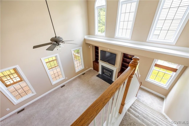 706 Colony Oak Ln, Midlothian, VA 23114 - staircase with a high ceiling, a fireplace with flush hearth, carpet, and ceiling fan