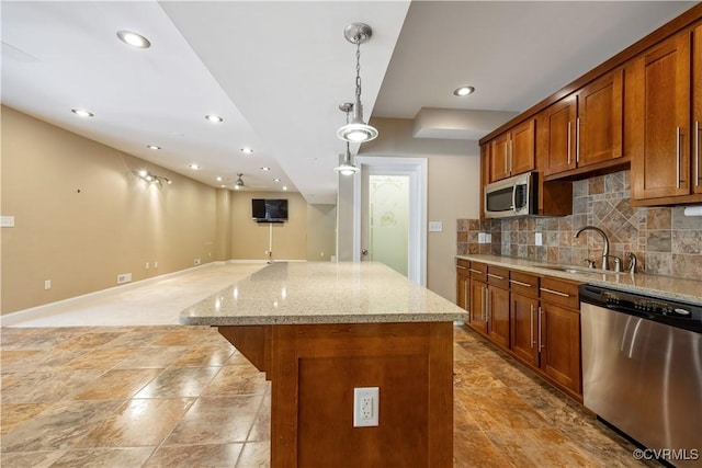 706 Colony Oak Ln, Midlothian, VA 23114 - kitchen featuring appliances with stainless steel finishes, decorative backsplash, brown cabinets, a center island, and light stone countertops