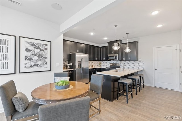 8034 Wistar Glen Dr Unit A, Henrico, VA 23228 - kitchen featuring appliances with stainless steel finishes, a peninsula, a breakfast bar area, light countertops, and decorative backsplash